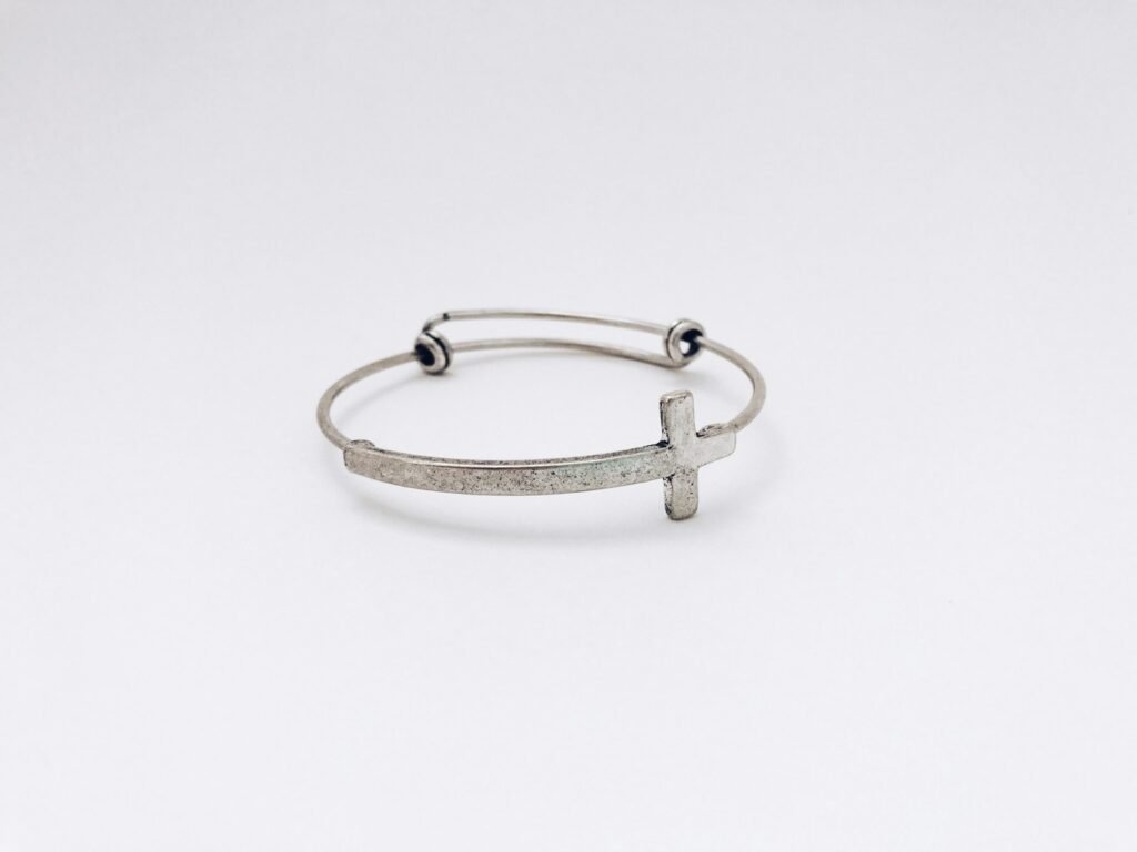 closeup photo of silver-colored cross bangle