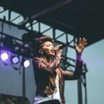 selective focus photography of woman raising left hand