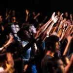 people raising their hands during night time