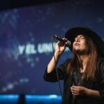 woman in black hat singing