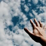 person hand reaching for the sky
