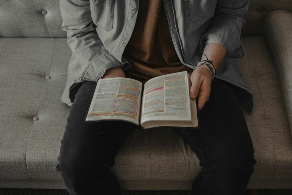 person in gray denim jacket reading book - what does the number 3 mean in the bible