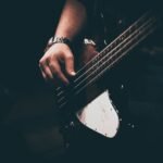 person playing white and black electric guitar