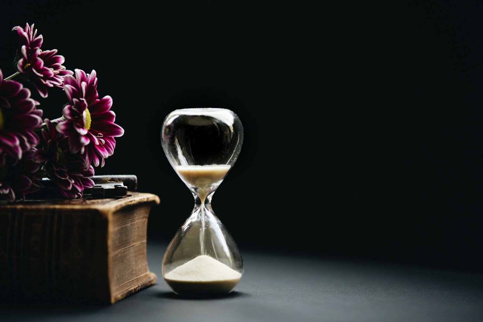 clear hour glass beside pink flowers - what does the bible say about time