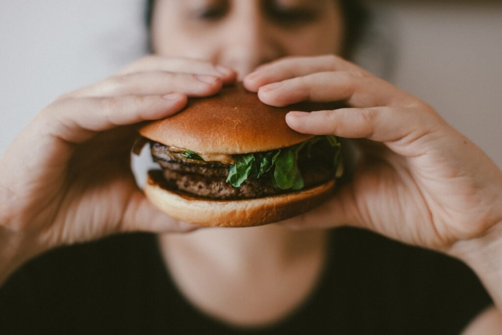 person holding burger - what does the bible say about eating meat