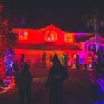 people standing near house with red light decor during night time - is it a sin to celebrate halloween as a christian