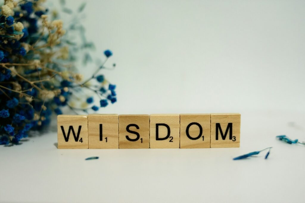 a wooden block spelling the word wisdom next to a bouquet of flowers - what does the bible say about wisdom